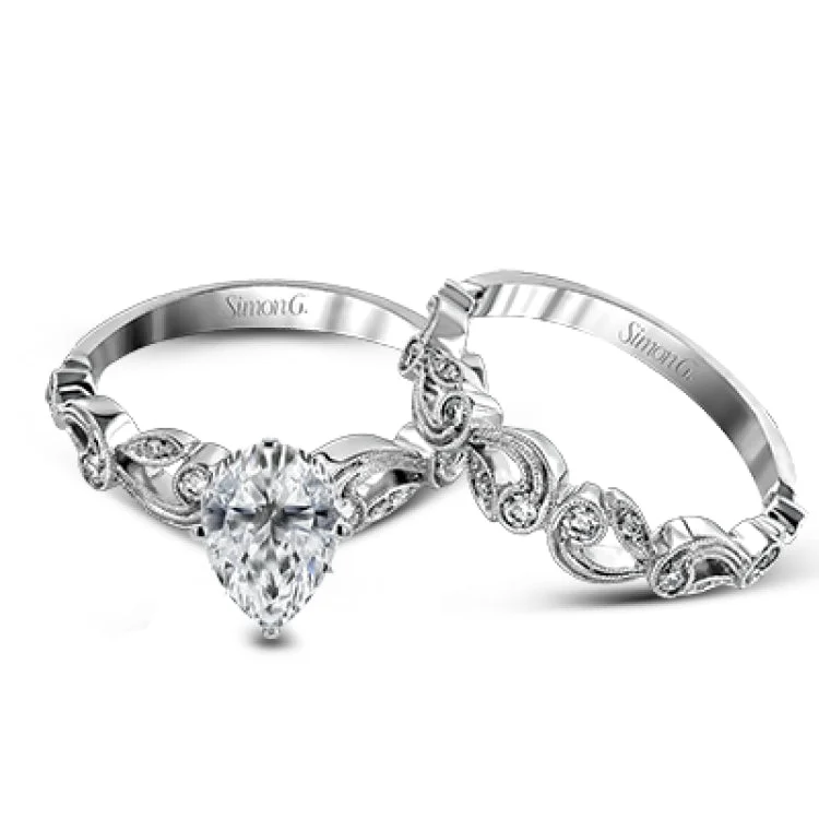 Women’s wedding and engagement rings-This delicate floral inspired white gold engagement ring and wedding band set is accentuated with .28 ctw shimmering round cut white diamonds.