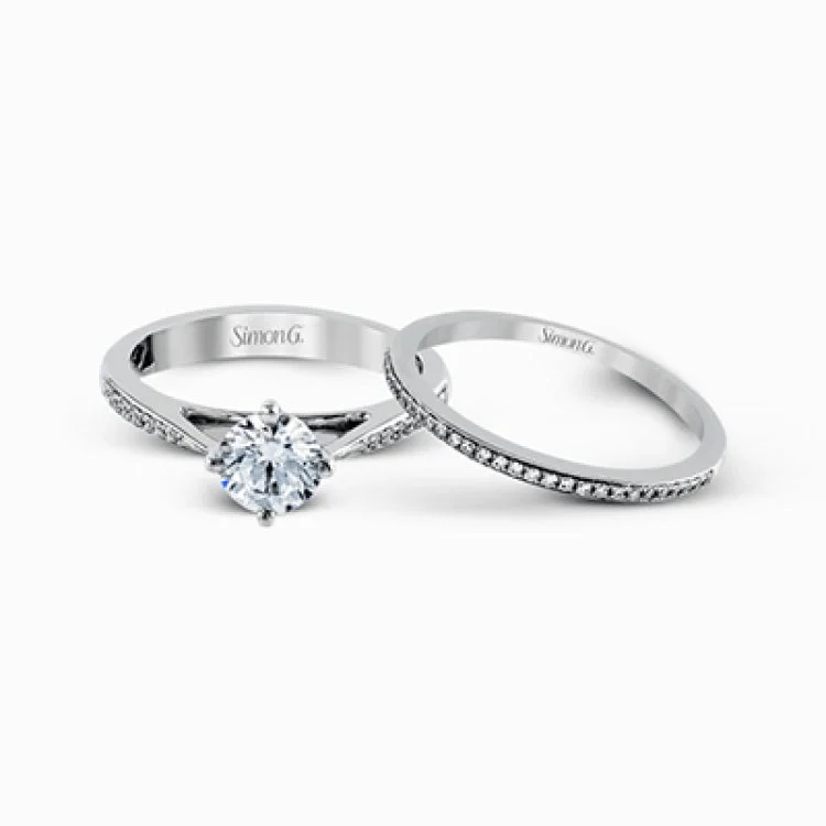 Women’s diamond halo engagement rings-The elegant design of this classic white gold engagement ring and wedding band is complemented by .21 ctw of glimmering round cut white diamonds.