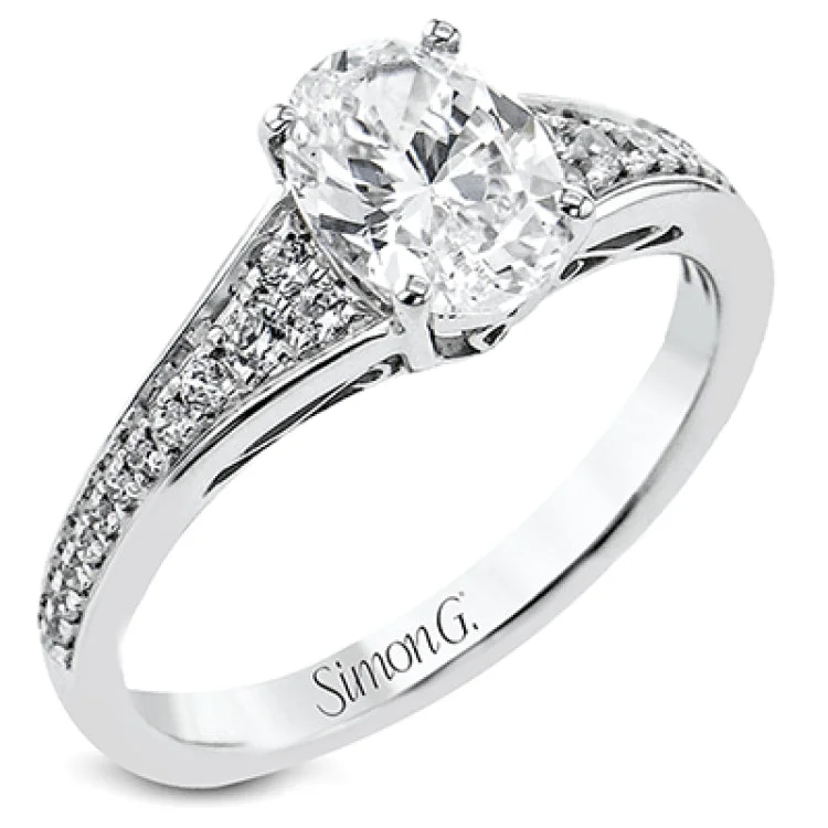 Women’s diamond rings with intricate designs-This white gold engagement ring takes an oval center stone and has a tapered shank, with diamonds .22 ctw graduating in size down the sides. On the profile there is hand carved filligree design.