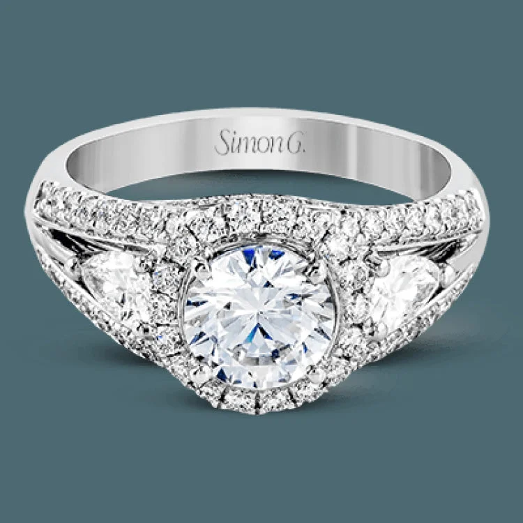 Women’s halo diamond engagement rings-The elegant design of this classic white gold engagement ring is set with .62 ctw of round cut white diamonds and .40 ctw pear shaped white diamonds.