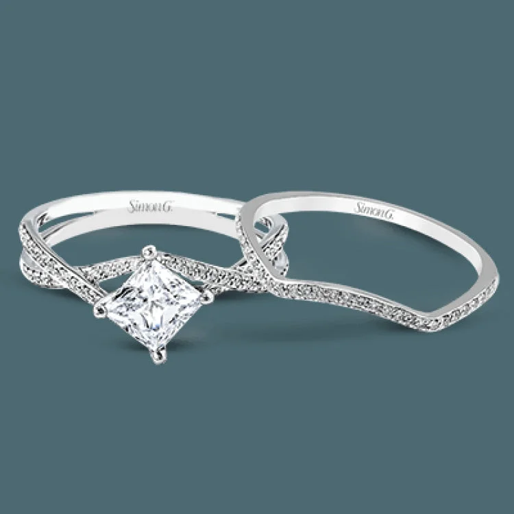 Women’s engagement rings with a twist-This dramatic white gold engagement ring and wedding band set are highlighted by .23 ctw of dazzling round cut white diamonds in a distinctive modern twist design.